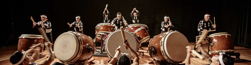 Musique Taiko - Définition du taiko, dans l'image on voit une série de percussionnistes de Taiko dans un spectacle.